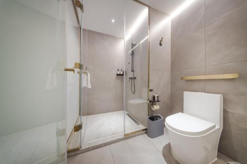 a white bathroom with a shower and a toilet at Atour Light Hotel Chengdu Dujiangyan in Dujiangyan