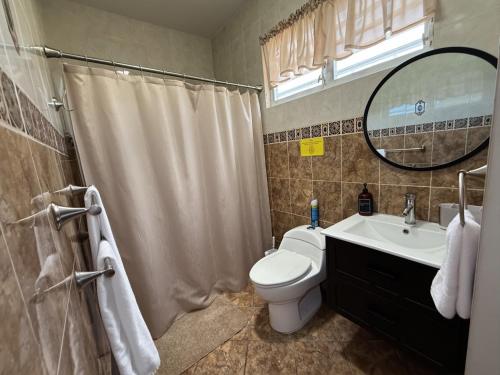 a bathroom with a toilet and a sink and a mirror at LaPlaya in Manati