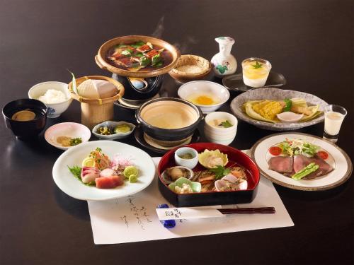 a table with plates of food and bowls of food at Oyado Yumechidori in Saga