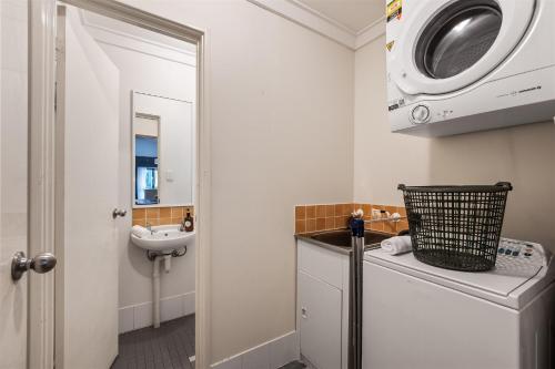 Un baño con lavabo y lavadora. en TreeTops Margaret River, en Margaret River Town