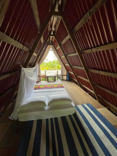 a bed in a small room with a window at Salvaje trip in Nuquí