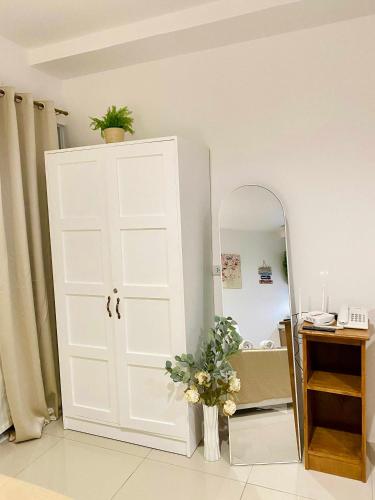 a bathroom with a white door and a mirror at Kozzy Loft Sitari Condominium in Bacolod