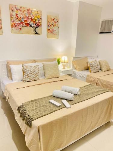 a bedroom with two beds with towels on them at Kozzy Loft Sitari Condominium in Bacolod