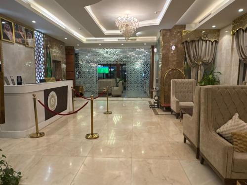 a lobby with a waiting area with chairs and a chandelier at شقق سوار الذهب للشقق المخدومة in Sīdī Ḩamzah