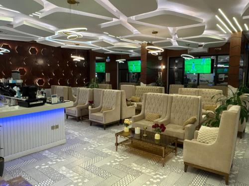 a waiting room with couches and tables and televisions at شقق سوار الذهب للشقق المخدومة in Sīdī Ḩamzah