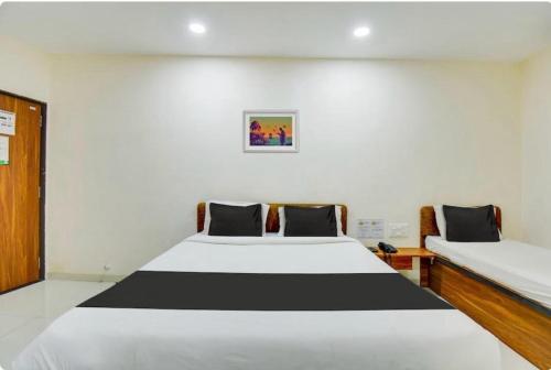 a bedroom with a large white and black bed at Hotel O Grand Executive in Chikalthān