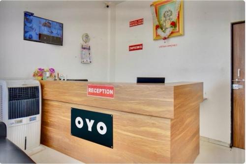 a reception desk in an office with axo sign on it at Hotel O Grand Executive in Chikalthān