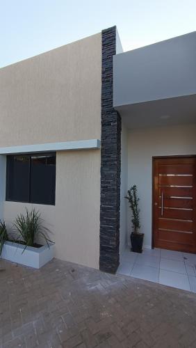 a building with a wooden door and two potted plants at Duplex UNI in Encarnación