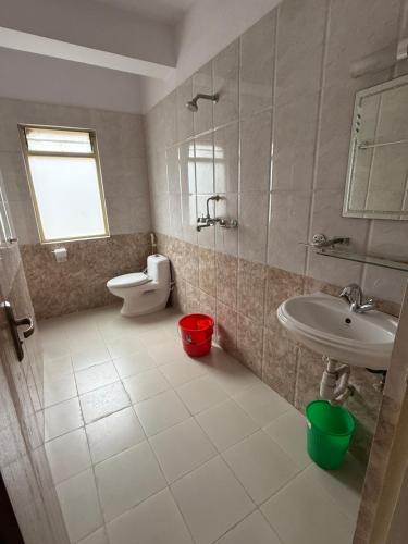 a bathroom with a sink and a toilet and a sink at Home Guest House in Kathmandu