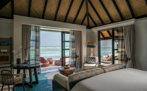 a bedroom with a bed and a view of the ocean at Four Seasons Resort Maldives at Kuda Huraa in North Male Atoll
