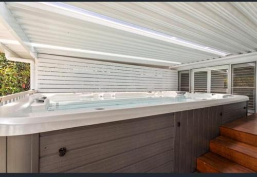 a large bathroom with a large bath tub at Family Beach House with Swim Spa in Nelson Bay