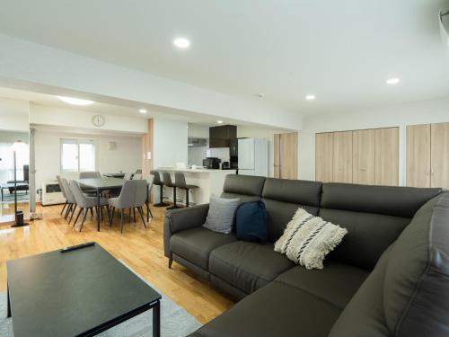 a living room with a couch and a table at CleanNest Hokkaido Sapporo Kita33jyou in Sapporo