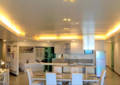 a kitchen with a table and chairs and a kitchen with a kitchen at Karon beach Stylish large 2BR with Sea View in Karon Beach