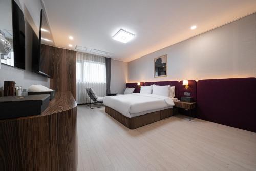 a hotel room with a bed and a television at Hound hotel gunsan in Gunsan