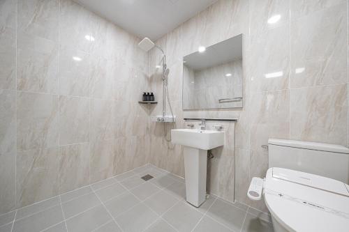 a bathroom with a sink and a toilet and a mirror at Hound hotel gunsan in Gunsan