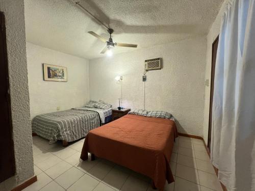 a room with two beds and a ceiling fan at Marqués 100 Exmarquesado in Oaxaca City