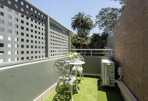 a patio with two chairs and a table on a balcony at Sun, Sand and Stay-Heart of Manly with free parking in Sydney