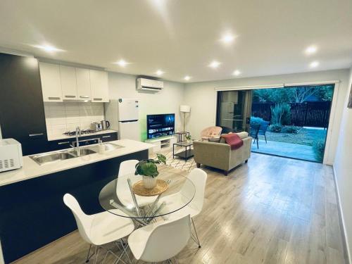 una cucina e un soggiorno con tavolo e sedie di Calm Getaway Close to Airport a Melbourne