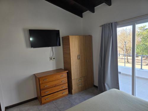 a bedroom with a dresser and a tv on the wall at El Punto Las Varillas in Las Varillas