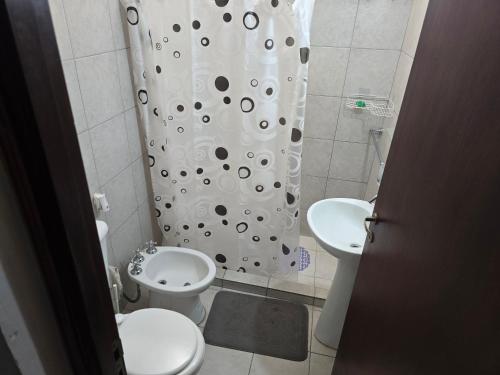 a bathroom with a toilet and a shower curtain at El Punto Las Varillas in Las Varillas
