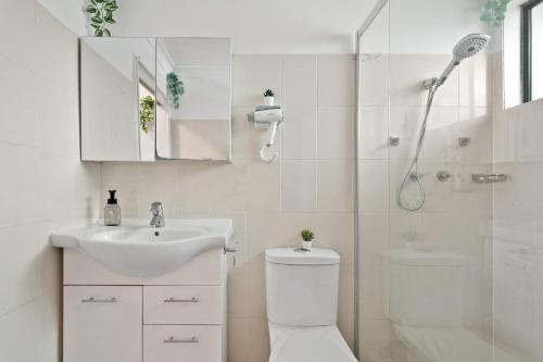a bathroom with a shower and a toilet and a sink at Courtyard Double Room in Peakhurst - Central Location - Shared Bathroom in Peakhurst