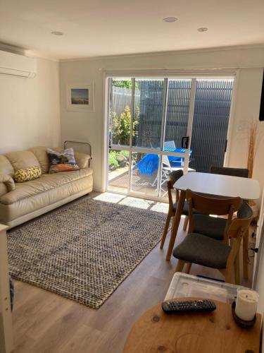 a living room with a couch and a table at Maraetai Beachfront bliss one bedroom apartment in Maraetai