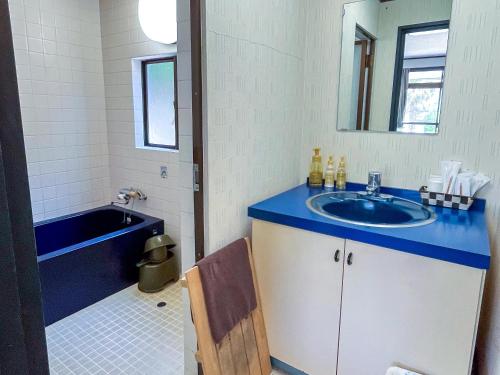 a bathroom with a blue sink and a tub at Sea Tiger Island Inn Shodoshima in Shodoshima