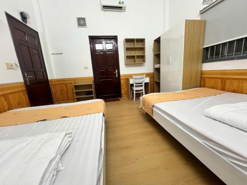 a bedroom with two beds and a table in it at Công Ty TNHH SẢN XUẤT & THƯƠNG MẠI PHÚC ĐẠT in Xom Ông Linh