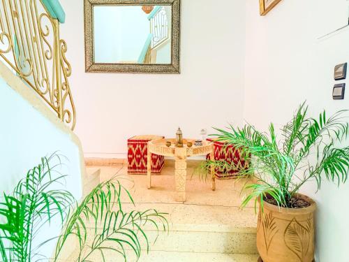 a room with plants and a table and a mirror at Riad medina d'or in Marrakech