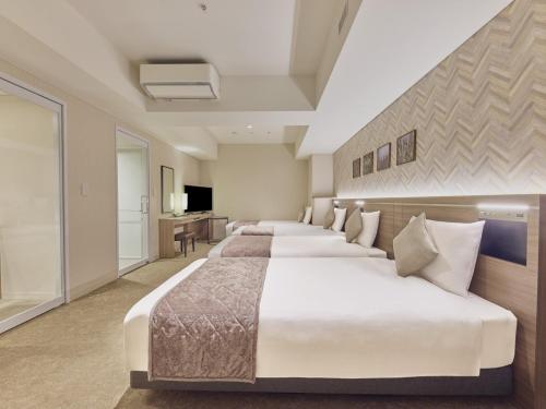 a row of beds in a hotel room at Villa Fontaine Grand Tokyo Ariake in Tokyo