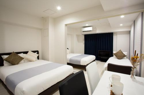 a hotel room with two beds and a dining room at BON Condo Namba Nipponbashi in Osaka