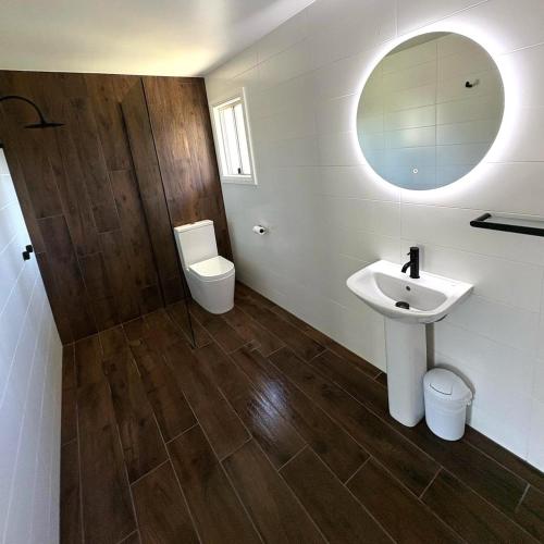 a bathroom with a sink and a toilet and a mirror at Hotel Theodore in Theodore