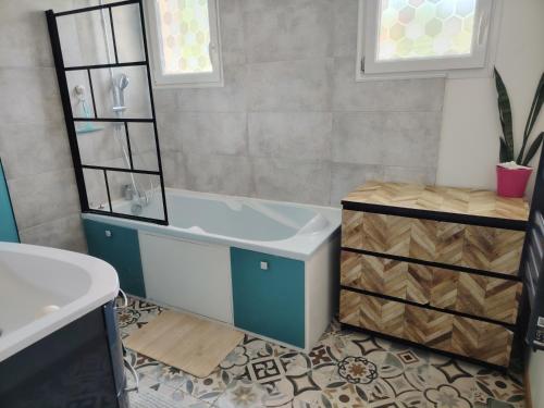 ein Badezimmer mit Badewanne und Waschbecken in der Unterkunft Maison petit havre de paix in Aytré