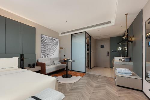 a bedroom with a bed and a living room at Atour S Hotel Xiamen Gaoqi Airport Huli District Government in Xiamen