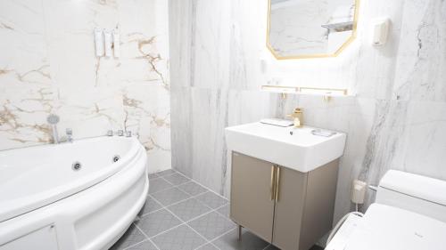 a white bathroom with a sink and a toilet at Taebaek Hotel in Taebaek