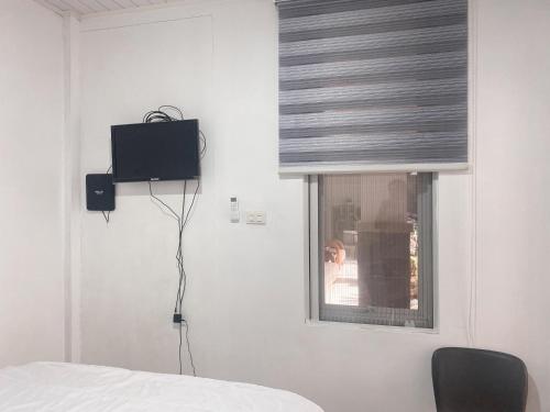 a room with a bed and a window with a television at Urbanview Hotel Hakobox Syariah Lampung by RedDoorz in Bandar Lampung