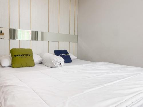 a large white bed with two pillows on it at Urbanview Hotel Hakobox Syariah Lampung by RedDoorz in Bandar Lampung