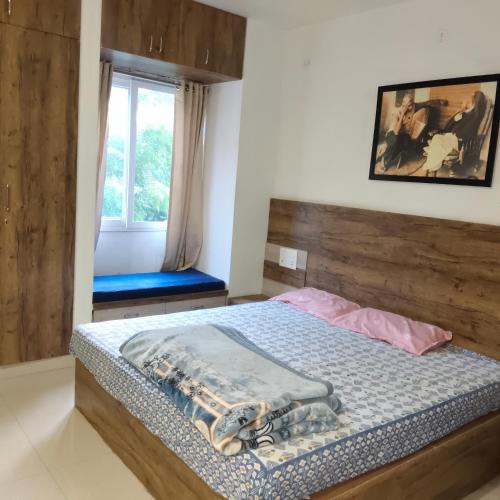 une chambre avec un lit avec une tête de lit en bois et une fenêtre dans l'établissement Silk Road Suite, à Jaipur