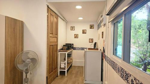 a kitchen with a refrigerator and a window at Black Sheep House Khaoyai by ALPHATEL PARTNER in Pong Talong