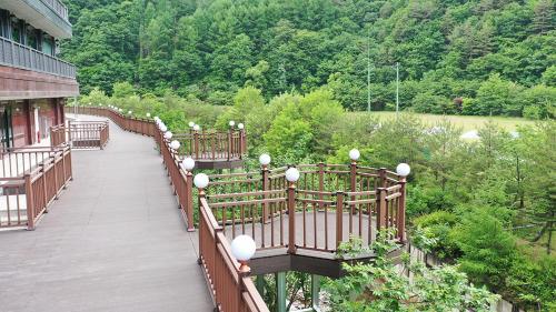 a wooden walkway with benches and lights on a building at Taebaek Hotel in Taebaek