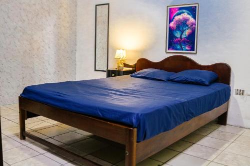 Un dormitorio con una cama con una colcha azul. en Hostal casa el calvarito, en León