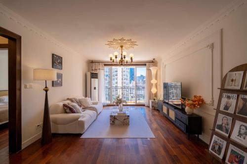 a living room with a couch and a chandelier at Book and Bed-People's Square in Shanghai