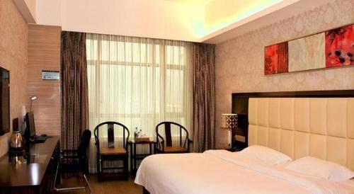 a bedroom with a large bed and a table and chairs at Fuzhou Xin Zi Yang Hotel in Fuzhou