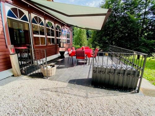 a patio with a table and chairs and an umbrella at Mariazeller Alpen Chalet in Mariazell