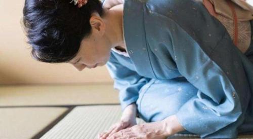 a man sitting on the floor with his arm on the floor at Futami Onsen Hotel Seikai in Ise