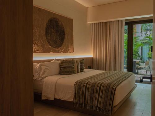 Un dormitorio con una cama y una ventana grande. en Osh Hotel Cartagena, en Cartagena de Indias