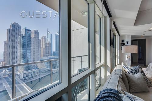 a living room with a couch and a large window at Al Majara by EMAAR, Dubai Marina in Dubai