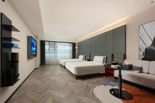 a hotel room with a bed and a couch at Atour S Hotel Xiamen Gaoqi Airport Huli District Government in Xiamen