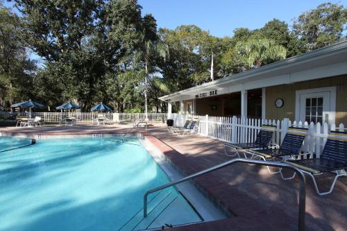 een zwembad met stoelen en een gebouw bij Sherwood Forest Premium Loft Cottage 13 in Kissimmee