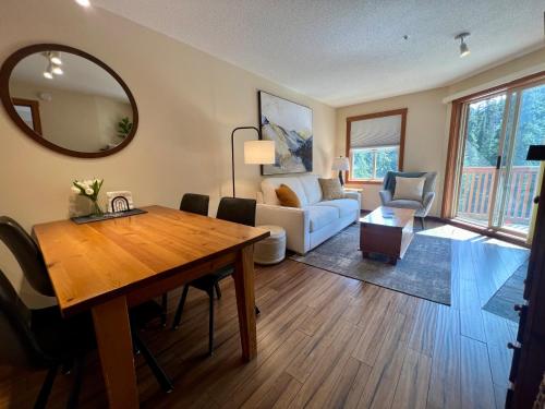 a living room with a wooden table and a couch at Main Village, Ski-in Ski-out, Hot Tub, Condo in Sun Peaks